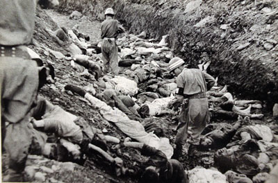 July 1950: U.S. -backed South Korean soldiers walk among thousands of political prisoners shot by South Korea at Taejon.