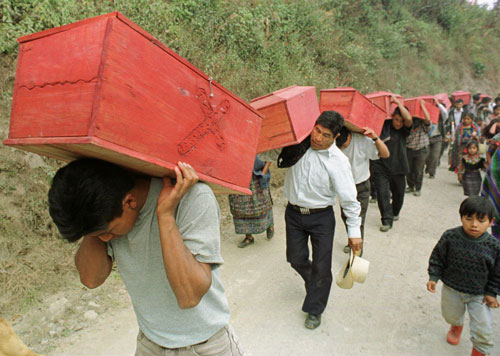 Guatemala, January 1999. Mayan men carry the coffins of victims killed by Guatemalan government in 1982, to a reburial ceremony in Xecoxol, north of Guatemala City.