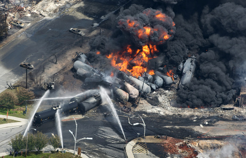 Smoke rises from derailed railway cars that were carrying crude oil out of Quebec, July 6, 2013.