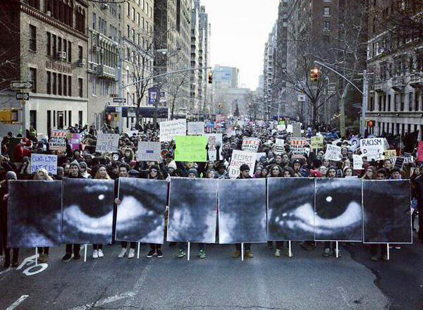 New York City, December 12, posters of the eyes of Eric Garner by French artist JR are carried in a march of thousands.