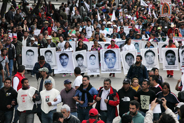 Relatives of the 43 missing students from the Isidro Burgos rural teachers college march holding pictures of their missing loved ones during a protest in Mexico City, December 26. Protesters marched through the city to mark the three months since the 43 students were taken by municipal police and then handed over to a drug gang to be killed and then the bodies burned, according to the results of the Attorney General's investigation. Photo: AP