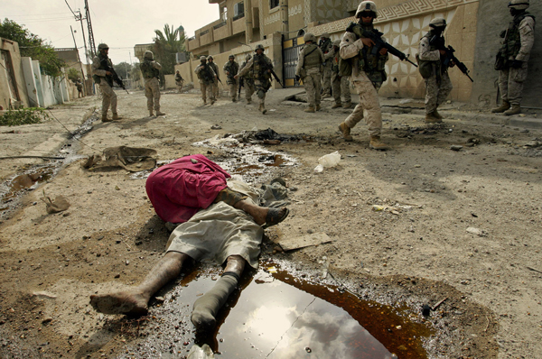 U.S. Marines walk past bodies of people killed in the U.S. assault on Fallujah, Iraq, 2004.
