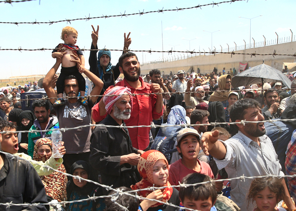 Syrian refugees waiting to cross the border into Turkey, June 15, 2014.