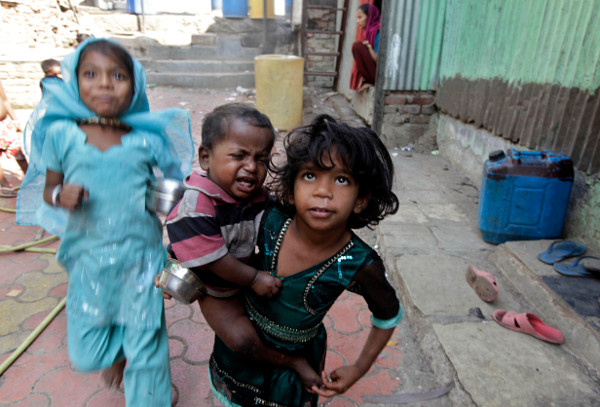 A girl holds a malnourished child outside a center that works with malnourished children in Mumbai, India (2012).