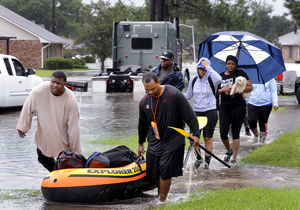 People evacuating a flooded neighborhood in Baton Rouge, Aug. 13