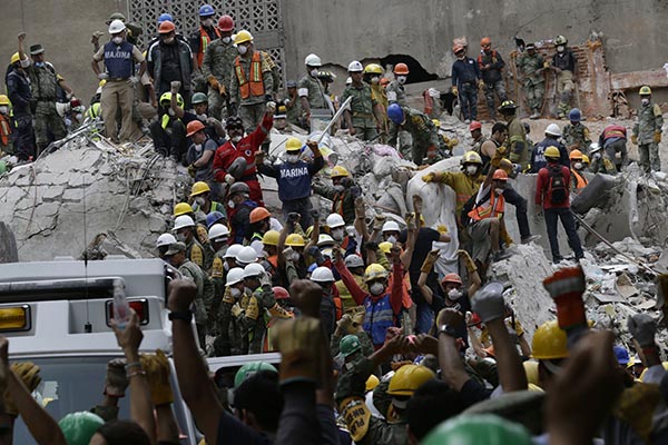 Thousands of volunteers work with professionals to remove debris of buildings collapsed by the powerful quake that hit Mexico September 19.