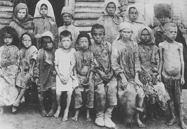 Fifteen starving children sit and stand for photo.
