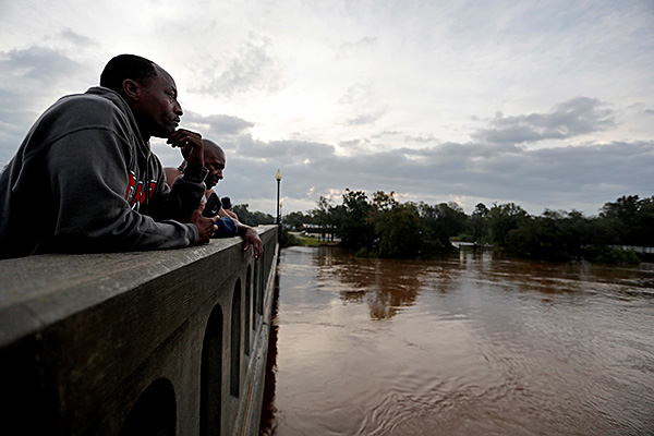 Floodwaters and storms, and their aftermath wreak their greatest havoc on poor, Black and oppressed peoples, and immigrants. Overlooking Cape Fear River, North Carolina, flooded by hurricane Florence, September 2018. (Photo: AP)