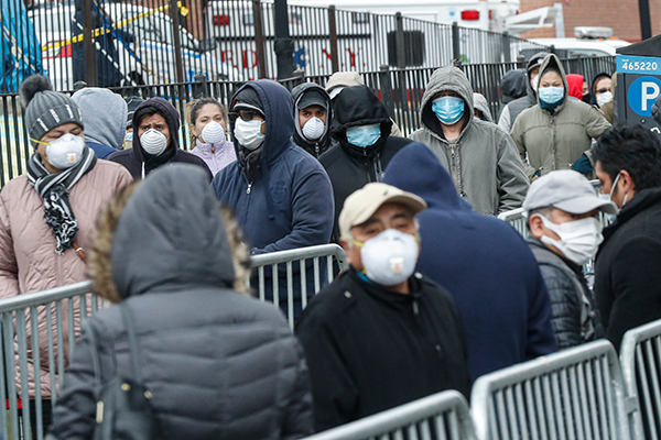 People wait in line to get into Elmhurst Hospital in Queens, New York.